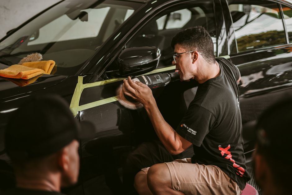 Professional auto detailer polishing a car to perfection